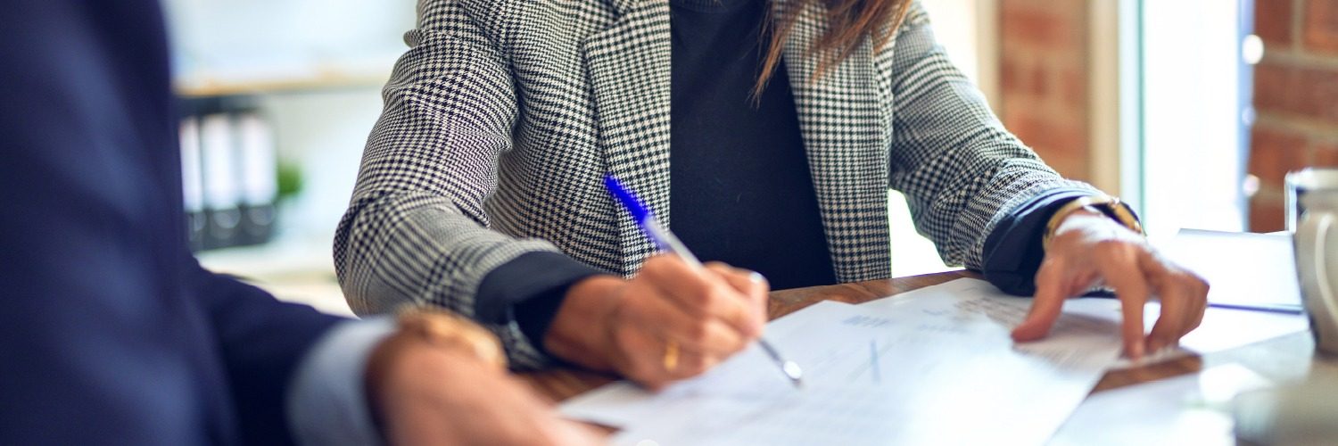 Exporting and International Trade – Woman signing work visa documentation Exporting and International Trade - Woman signing work visa documentation